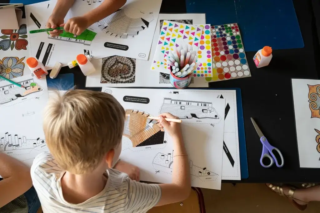 Enfants qui colorient et découpent une maquette du théâtre romain pendant un atelier au musée Lugdunum à Lyon