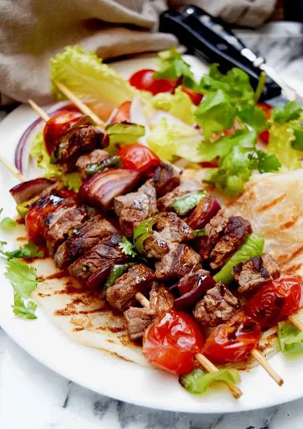 Brochettes de bœuf marinées grillées avec tomates cerises et poivrons