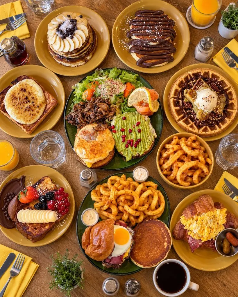 Table de brunch Sista Place Lyon : pancakes, gaufre, French toast, avocado toast, burger, croissant garni et curly fries