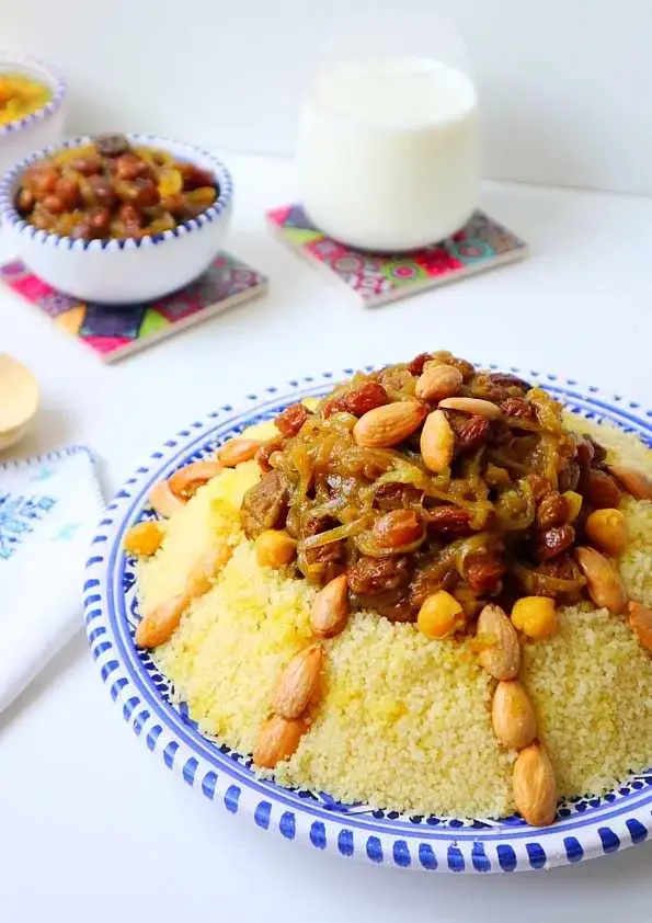 Couscous tfaya à l’agneau garni d’oignons caramélisés, raisins et amandes