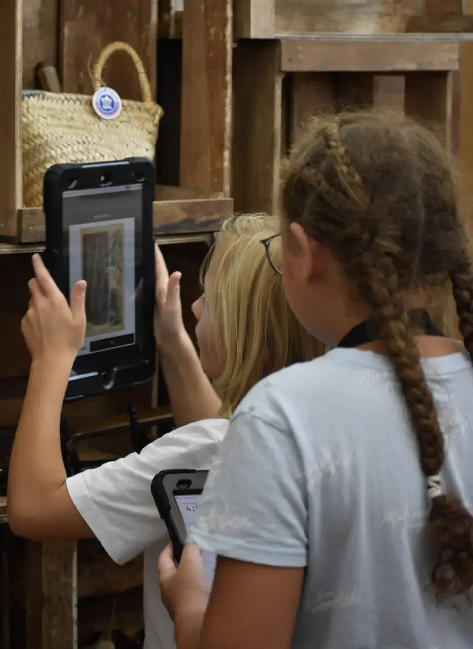Deux enfants résolvent une énigme sur tablette pendant le jeu Mission Forêts au Chalet du Parc à Lyon