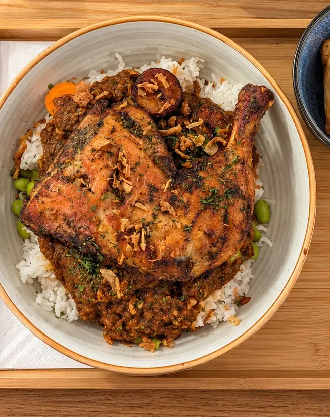 Cuisse de poulet braisée sur riz, sauce mijotée façon poulet DG, plantain et oignons frits au Baca Bamba, rue de Créqui à Lyon