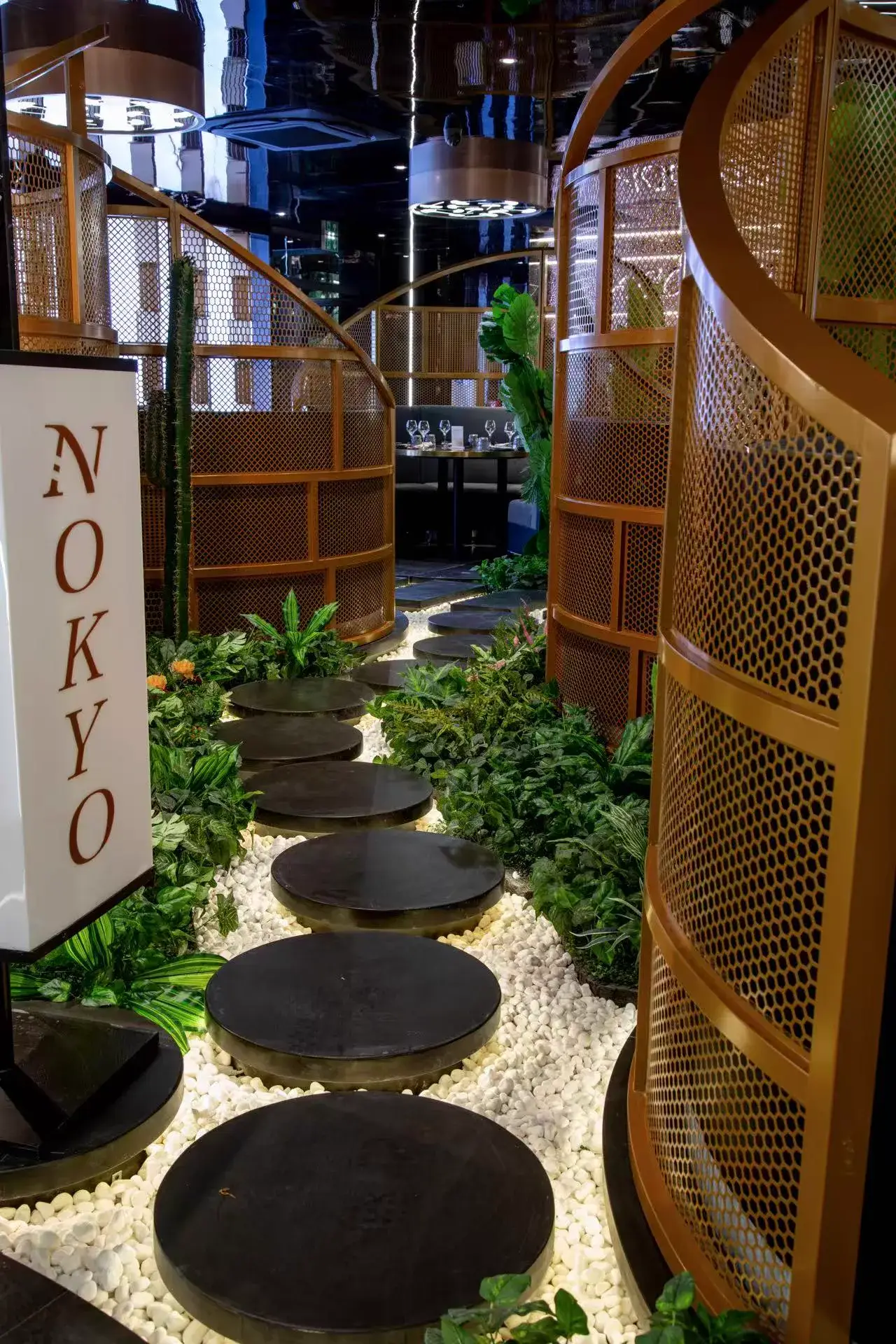 Allée de pas japonais entre les alcôves dorées du restaurant Nokyo