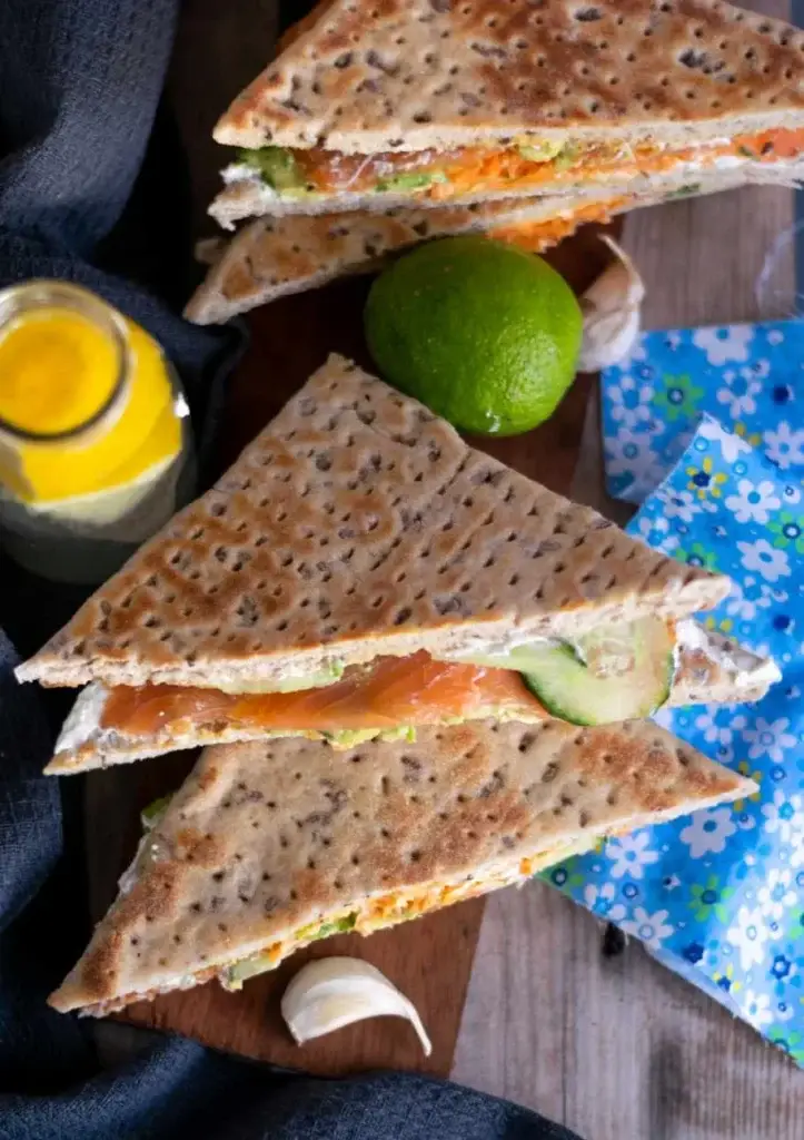 Sandwichs de pain suédois au saumon fumé, avocat et concombre coupés en triangles