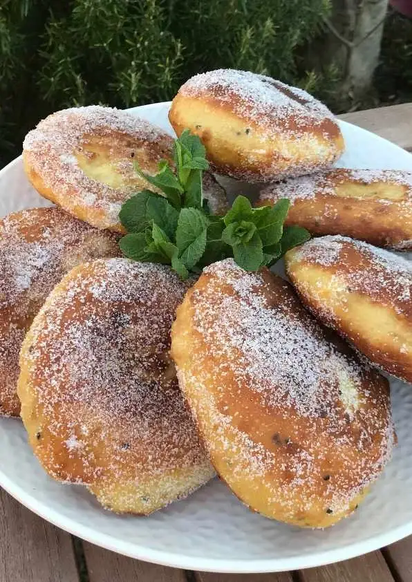 Petits pains frits saupoudrés de sucre dans une assiette