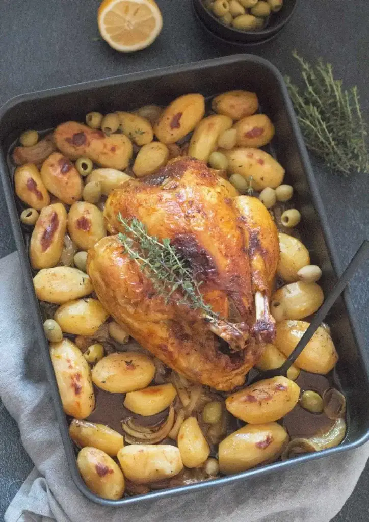Poulet rôti au thym entouré de petites pommes de terre dorées