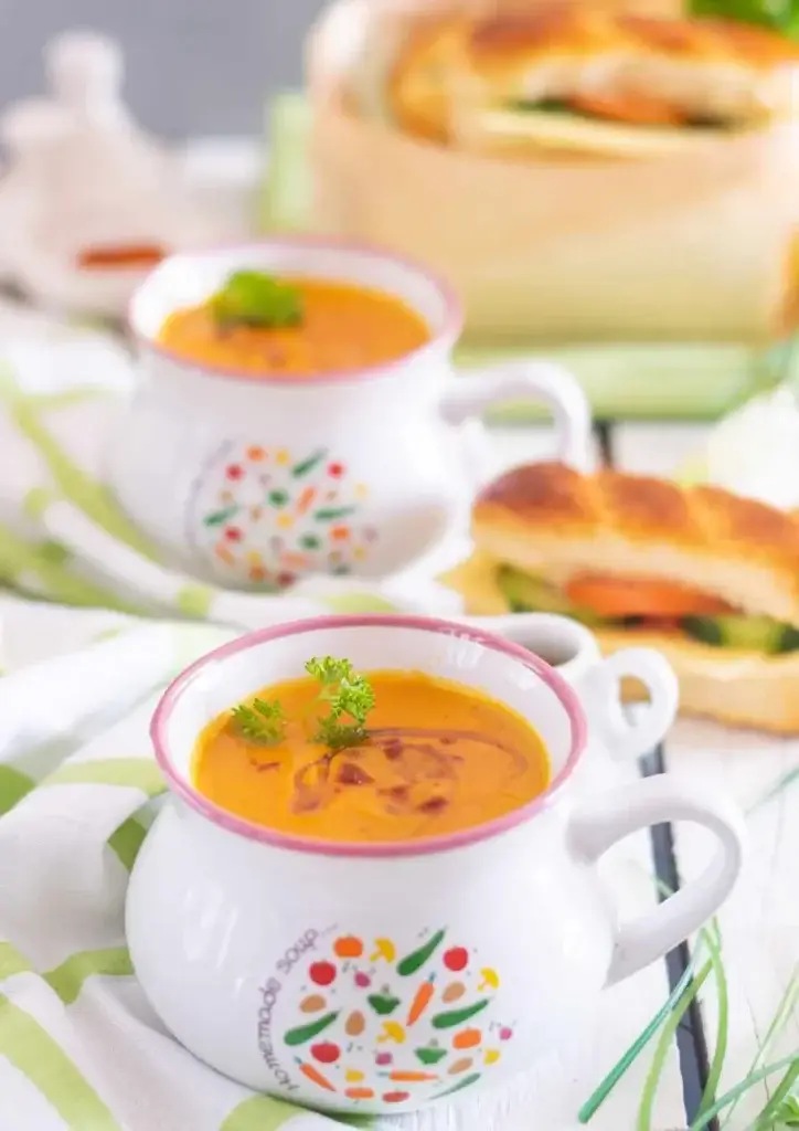 Velouté de carotte servi dans des bols avec persil et filet d’huile pimentée