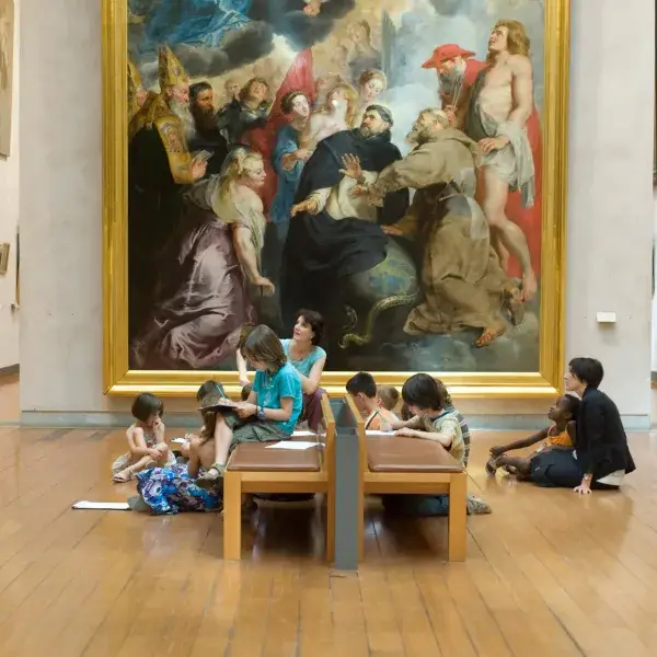 Enfants assis devant un grand tableau pendant une visite en famille au musée des Beaux-Arts de Lyon