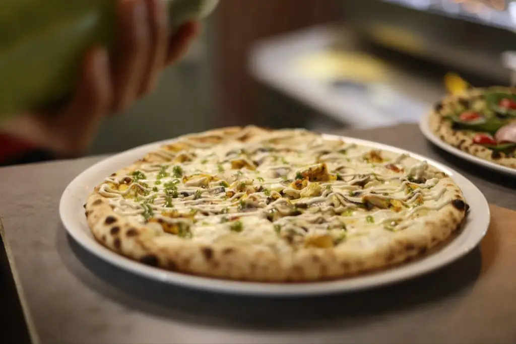 Pizza base crème cuite au feu de bois chez Vittoria, pizzeria italienne à Corbas